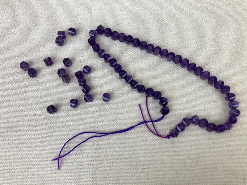 Amethyst Beads: Collection of polished amethyst beads showcasing rich purple tones and translucent natural variation. Ideal for jewelry making or craft projects. One bead measures approximately 1/4" in diameter. Good