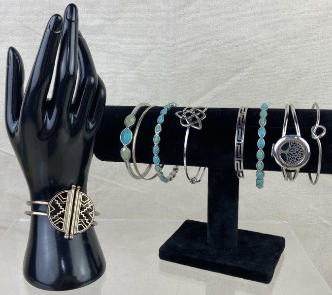 Lot of Silver-tone Bangles: Attractive collection of silver-tone bangles in assorted designs, including one Lucky Brand bangle. Features decorative elements such as turquoise and sea glass accents, along with motifs like the Cel