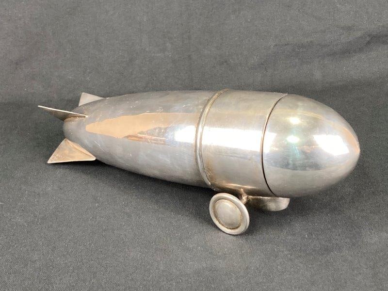 Silverplate Airplane Cocktail Shaker: Stylish and streamlined airplane-form cocktail shaker, perfect as a statement piece for the bar or display. Features a highly reflective silver plate surface and sleek modern lines evocative of early