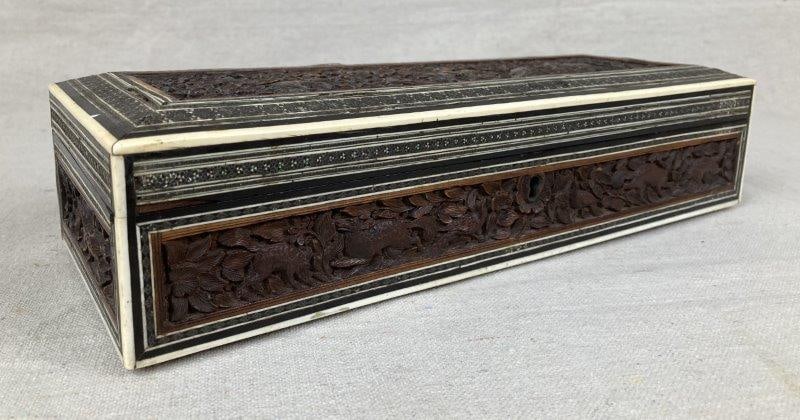 Heavily Carved Box with Bone Inlay: Exceptional hand-carved box featuring intricate bone trim with ebony stringing and deeply detailed floral and figural motifs. The carvings depict a man on horseback surrounded by elephants, birds, fox