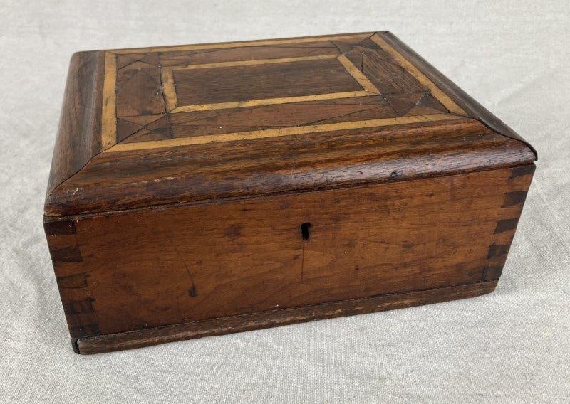 Marquetry Wood Box: Charming marquetry box featuring intricate geometric inlay work composed of a variety of woods. Constructed with dovetail joinery and fitted with a keyhole (key and lock not present), indicating forme