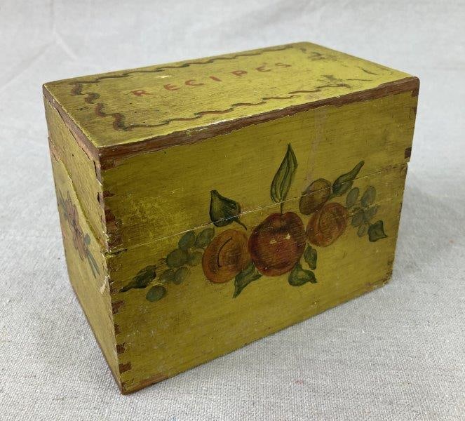 Globe-Wernicke Painted Recipe Box: Charming painted recipe box by Globe-Wernicke featuring hand-painted fruit details against a rich yellow ground, exuding vintage kitchen charm. Measures approximately 4 1/8" H x 5 1/2" W x 3 1/8" D. S