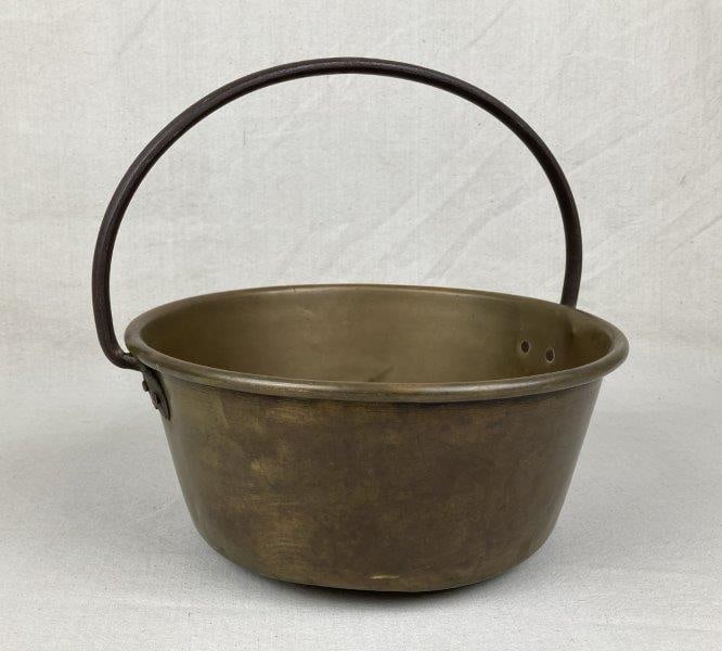 Brass and Iron Bucket: Hand-forged bucket featuring a sturdy iron swing handle and warm worn brass patina throughout. Classic utilitarian form with appealing age and surface character. Measures approximately 10'' H x 13'' W