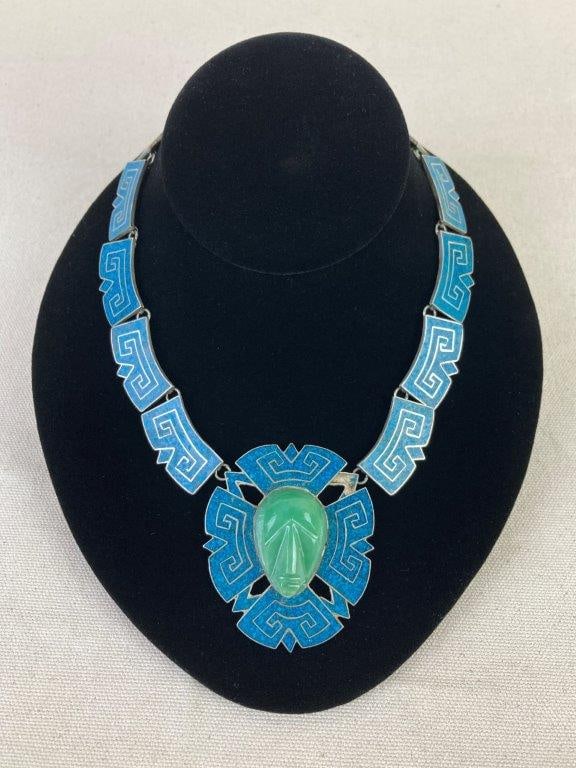 Taxco Sterling Silver Necklace with Turquoise Inlay & Carved Jadeite Mask: Taxco sterling silver necklace featuring a striking central carved jadeite mask flanked by angular panels of turquoise chip inlay, exemplifying classic Mexican artisan craftsmanship. The reverse is ma