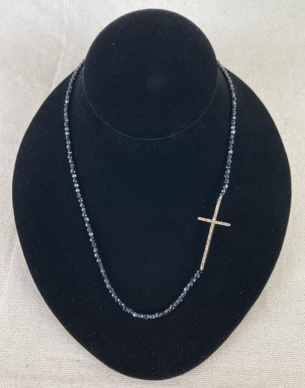 Carol Brodie Rarities Necklace: Sterling silver necklace featuring a horizontal cross pendant set with topazes that create a vibrant focal point, complemented by a strand of spinel black beads that add depth and shimmer. Clasp is ma