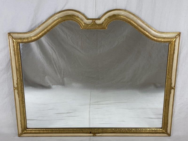 French Style Giltwood Mirror: A finely crafted French-style giltwood mirror featuring a shaped serpentine crest with a soft arch and elegant scrolled inner moldings. Measures approximately 39" H x 49" W x 3" D. In good condition w
