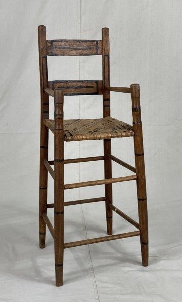 19th Century Country Painted High Chair: A charming 19th-century country high chair featuring turned legs, painted decorative elements, and a woven seat. Measures approximately 35" H x 12" W x 11" D. In good condition with wear consistent wi
