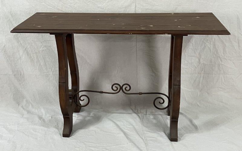 Spanish Revival Console Table: A Spanish Revival console table featuring lyre-shaped legs joined by a scrolled iron stretcher, all finished in a warm, traditional tone. Measures approximately 33" H x 54" W x 19" D. Shows some wear
