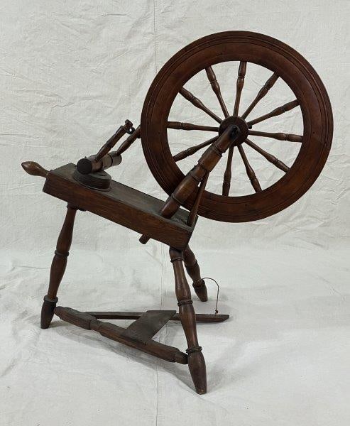 Antique Spinning Wheel: A charming antique spinning wheel, ideal for farmhouse or rustic dÃ©cor, showcasing a warm, aged patina that highlights its timeless craftsmanship. Measures approximately 36" H x 21" W x 35"
