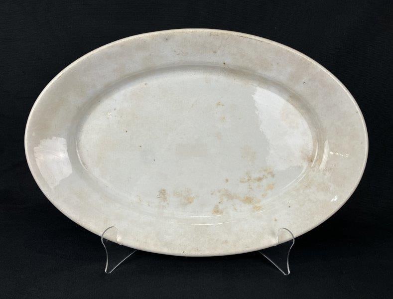Cook and Hancock Ironstone Platter: A semi-granite ironstone platter by Cook and Hancock, displaying natural discoloration and classic 19th-century form. Measures approximately 1 1/2" H x 17 5/8" W x 11 5/8" D. Shows discoloration, craz