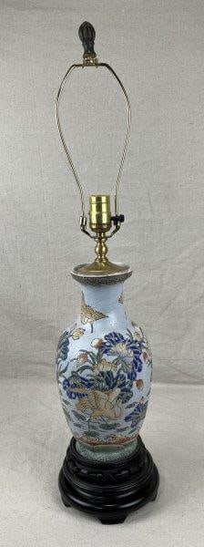 Chinese Porcelain Lamp: A Chinese porcelain lamp decorated with floral motifs and cranes rendered in vibrant tones. Measures approximately 30" H x 5 1/2" in diameter. In good condition with minimal wear.Untested.
