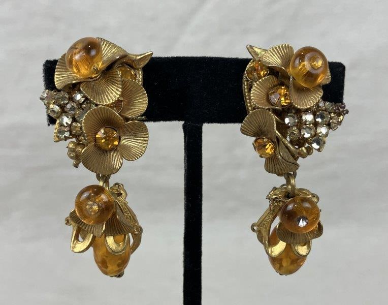 Vintage Miriam Haskell Clip On Earrings: Vintage clip-on earrings featuring a goldtone floral motif adorned with amber glass beads and small clear rhinestone accents, showcasing the brand's signature handcrafted detail. Stamped Miriam Haskel