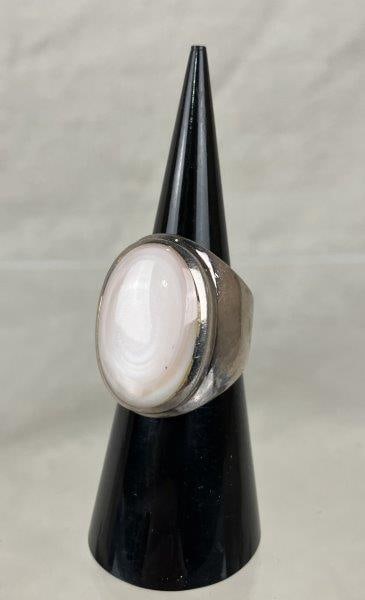 Sterling Silver and Shell Ring: Statement sterling silver ring featuring a polished shell cabochon set in a streamlined, robust band that complements the organic beauty of the stone. Ring size approx. 6, with a total weight of 11.71