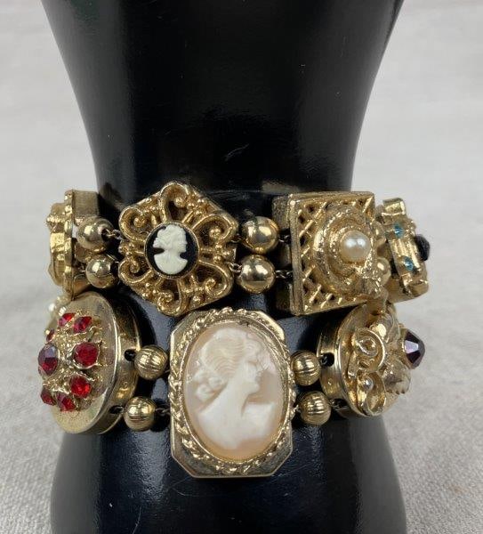 Victorian-Style Slide Charm Bracelet Pair: Pair of Victorian-style slide charm bracelets featuring an array of ornate gold tone slide stations set with rhinestones, faux pearls, cameos, and embossed motifs including serpents, busts, butterflie