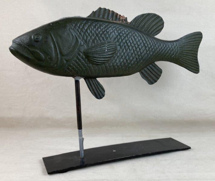 Fish Weathervane: A metal weathervane depicting a fish, has a nice dark green patina and modeled with nicely detailed features. Mounted on a black stand, the piece displays a worn surface patina that enhances its sculp