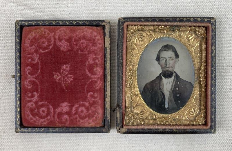 19th Century Daguerrotype of Civil War Soldier: A handsome 19th-century daguerreotype portrait depicting a well-dressed soldier, housed in a gold-plated decorative case with red fabric interior. The image retains visible silvering and displays an a