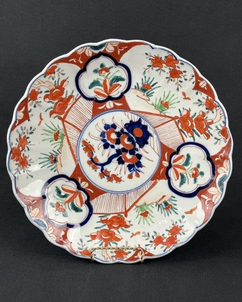 Japanese Imari Plate: A Japanese Imari plate decorated in characteristic vibrant cobalt blue, iron-red, and green tones, displaying a traditional palette and balanced decoration with a scalloped edge. Measures approximatel