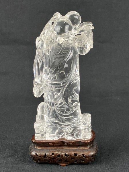 Chinese Quartz Crystal Carving of Dongfang Shuo: A finely carved Chinese quartz crystal figure depicting Dongfang Shuo, rendered with iconography typical of the legendary figure. Shown in traditional attire with a flowing beard and holding a branch,
