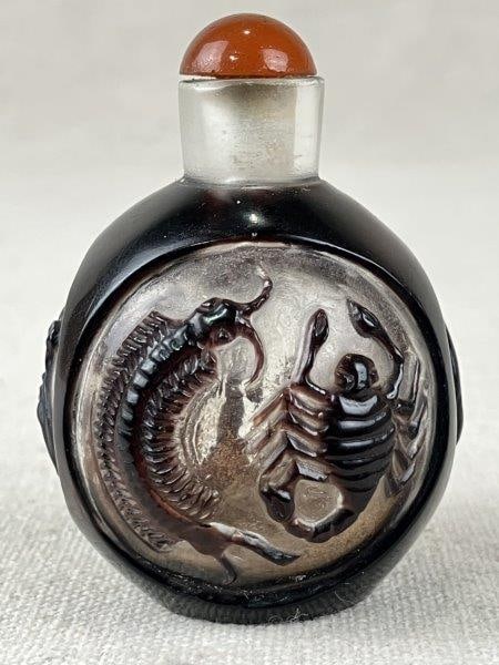 Chinese Peking Art Glass Snuff Bottle: A Chinese Peking art glass snuff bottle, showcasing intricate craftsmanship and technical virtuosity prized by collectors. The bottle is decorated with multiple panels featuring animal motifs, includi
