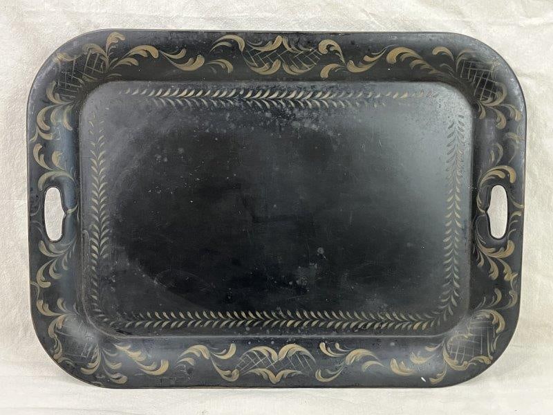 Toleware Tray: A painted toleware tray featuring a leafy vegetal design on a black ground, presenting an excellent example of traditional toleware artistry. Measures approximately 1â€³ H x 26 3/8