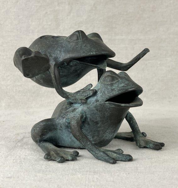Bronze Leaping Frogs Flower Frog: A playful and whimsical bronze flower frog sculpture depicting two frogs, one leaping onto the other’s back. The cast form features simple yet descriptive detailing and displays an attractive bl
