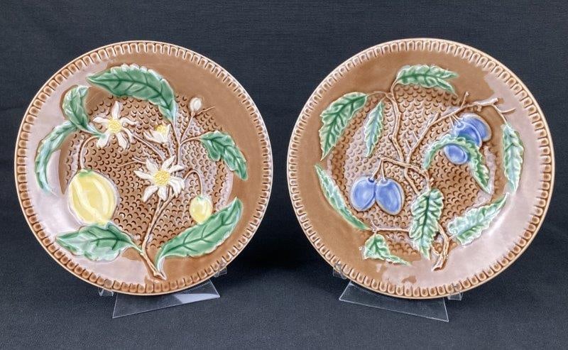 Pair of Majolica Fruit Plates by Bordallo Pinheiro: A pair of majolica fruit plates by Bordallo Pinheiro, one modeled with lemons and the other with plums. Founded in 1884, Bordallo Pinheiro is renowned for highly detailed, naturalistic majolica design