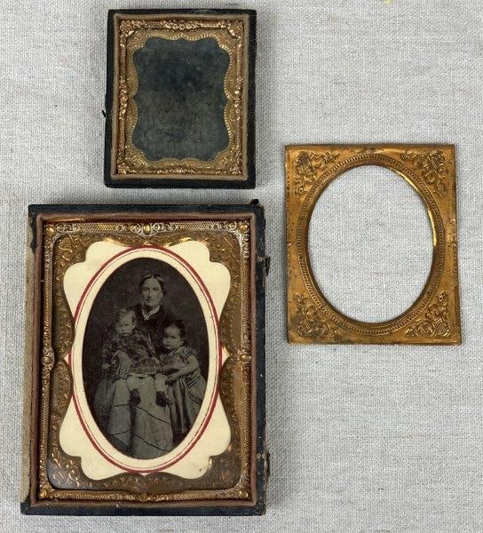 Two Framed Antique Photographs and Including One Tintype: An assembled group of antique photography comprising one framed photograph and one tintype. One photograph depicts a mother with two children housed in an embossed frame, while another appears as a fa