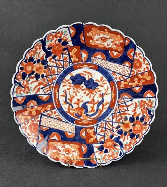 Japanese Imari Plate: A Japanese Imariware plate decorated in characteristic vibrant cobalt blue, iron-red, and green tones, displaying traditional palette and decorative balance with scalloped edge. Measures approximately