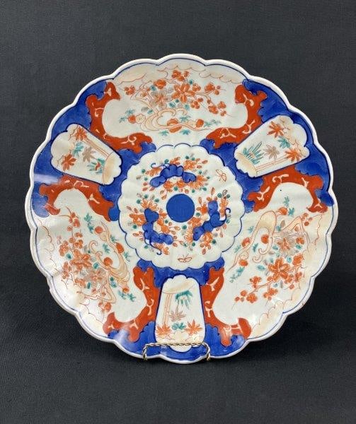 Japanese Imari Plate: A Japanese Imariware plate decorated in characteristic vibrant cobalt blue, iron-red, and green tones, displaying traditional palette and decorative balance including a scalloped edge. Measures approx