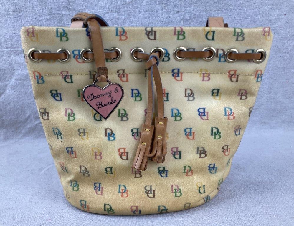 Vintage Dooney & Bourke Shoulder Bag: Vintage Dooney & Bourke shoulder bag featuring a Y2K-era multicolored DB monogram on coated canvas, complemented by leather trim and straps. Accented with a heart-shaped fob stamped Dooney & Bourke