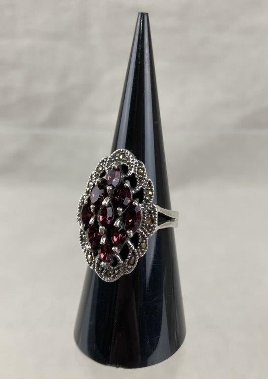 Sterling Silver, Marcasite, and Garnet Cluster Ring: Sterling silver ring featuring a cluster of reddish-purple rhodolite garnets arranged in a floral-style formation, framed by elegant scrolled silverwork set throughout with sparkling marcasite