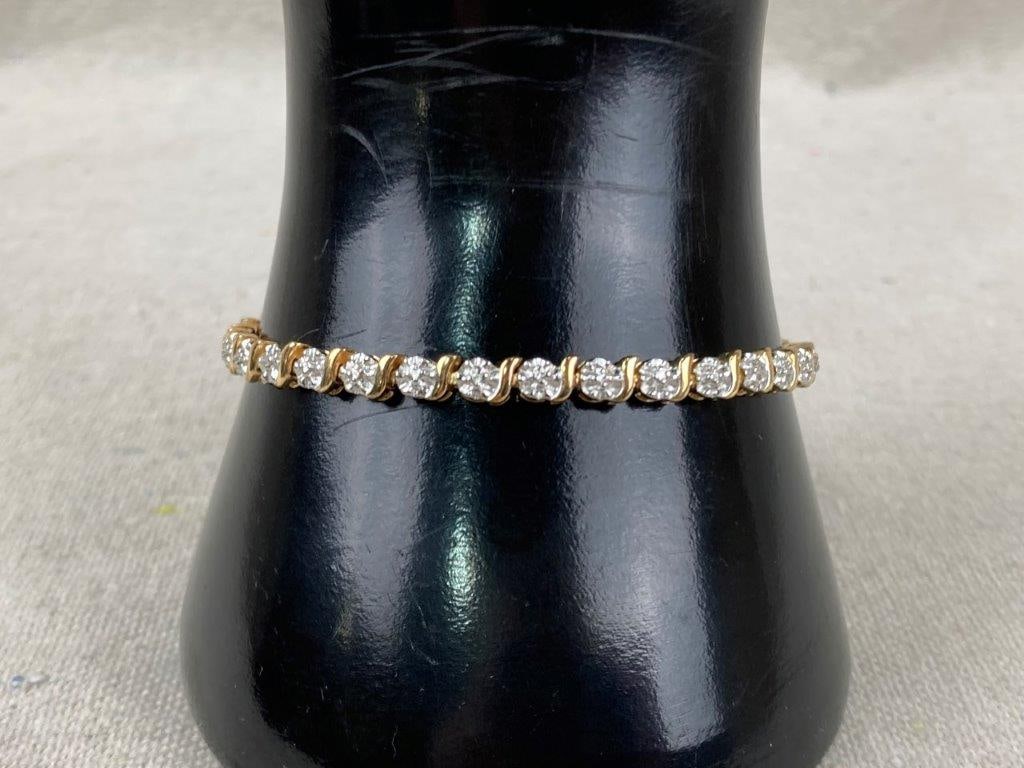 Sterling Silver with Gold Vermeil Heart Tennis Bracelet: Sterling silver tennis bracelet accented with gold vermeil, featuring a heart motif set with clear faceted stones and pink topaz accents. The surrounding bracelet displays textured silver links that e