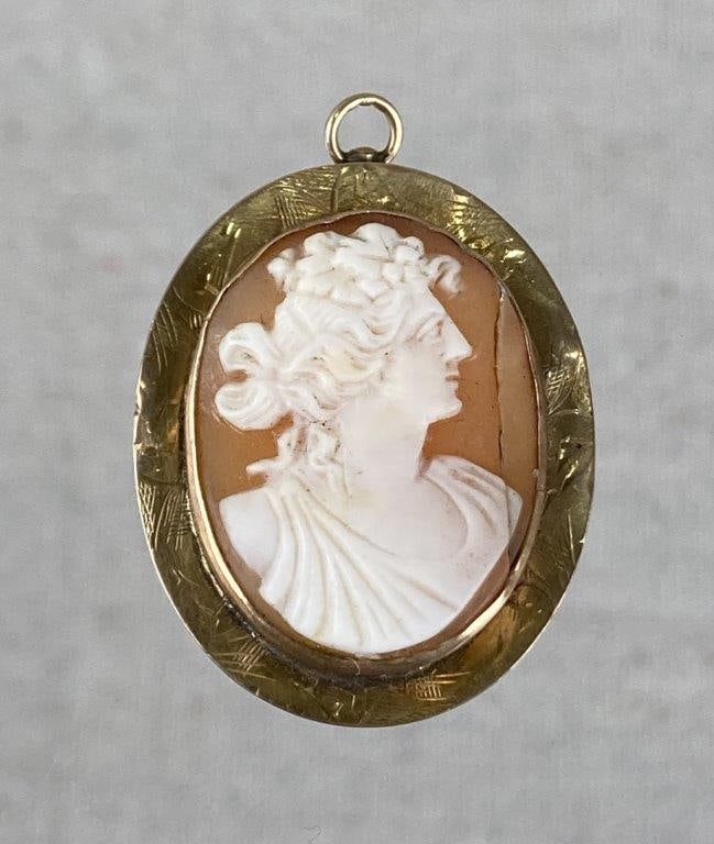 Vintage 10K Shell Cameo Pendant: Victorian-style shell cameo featuring a finely detailed female mythological figure carved in relief against a warm pinkish-orange ground, mounted in tested 10K yellow gold. The gold mount is accented