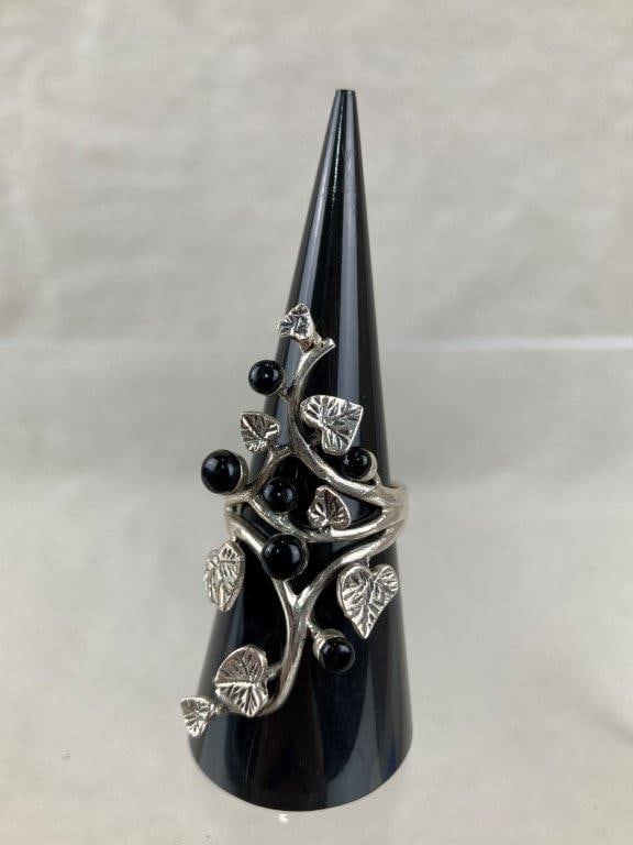 Vine Leaf Sterling Silver Ring: Sterling silver ring featuring an intricate open leaf-and-vine design that extends gracefully beyond the band, accented with small black onyx stones for contrast. Stamped 925 for sterling content. Rin