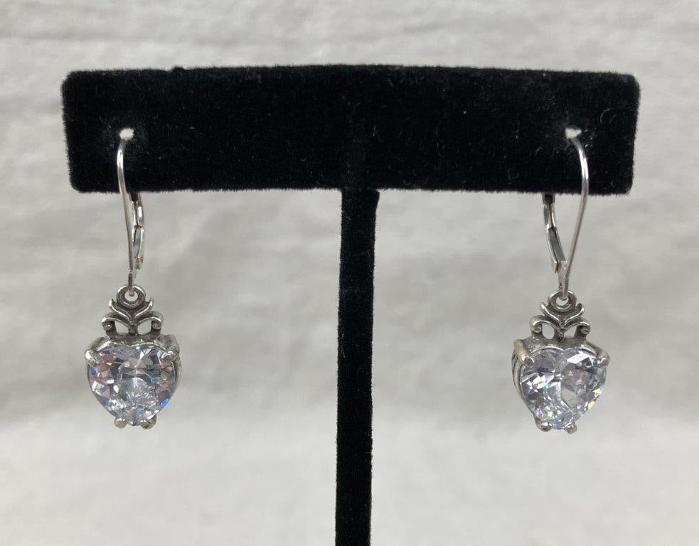 Sterling Silver Heart Earrings: Sterling silver earrings set with heart-shaped cubic zirconia stones, framed by an elegant scrollwork setting that adds movement and decorative detail. Stamped 925 for sterling content. One earring