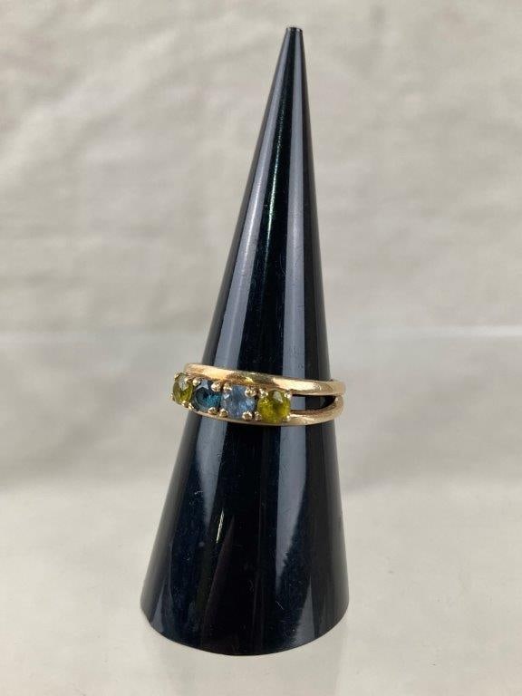 14 Kt Gold Multi-Gemstone Ring: 14 kt gold ring set with a variety of faceted brilliant-cut gemstones, including likely blue topaz, blue zircon, yellow topaz, and additional stones, arranged in a colorful composition reminiscent of