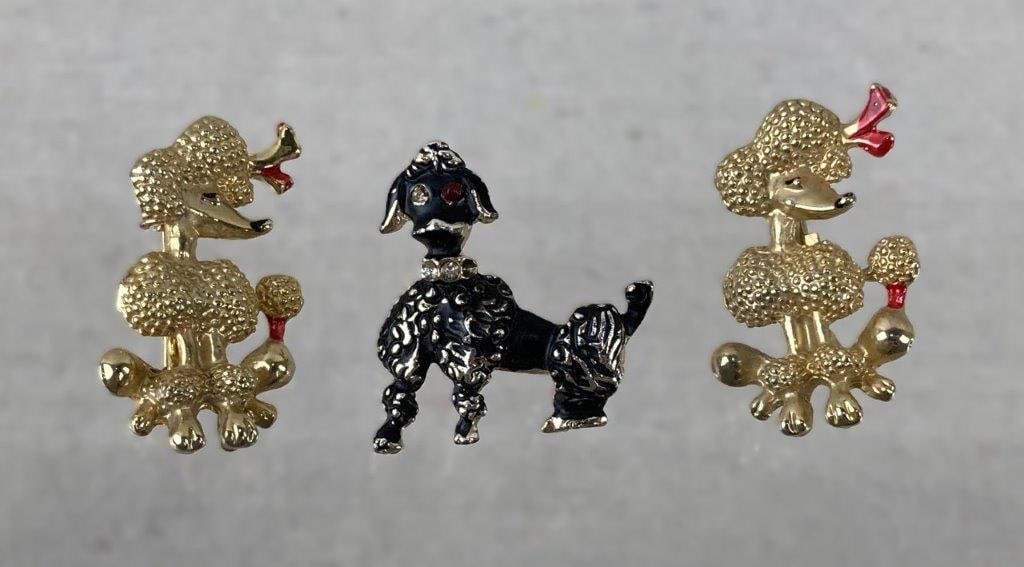 Three Vintage Poodle Brooches: Three-piece assortment of vintage costume jewelry brooches depicting poodles, rendered in goldtone and silvertone finishes with excellent enamel work. Whimsical dog-form designs throughout. One