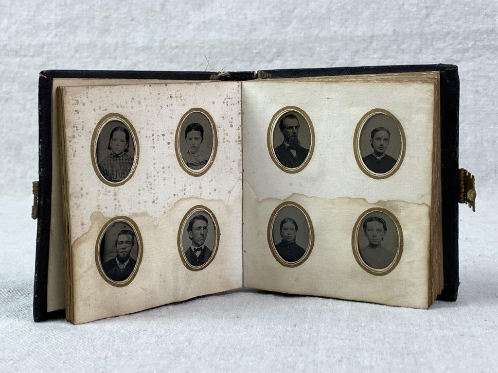 Late 19th Century J. E. Tilton and Co Gem Tintype Photo Album: A late 19th century gem tintype photograph album containing coin-sized tintype portraits housed within a small leather-bound volume. The album features a gold-tone clasp and an embossed cover design,