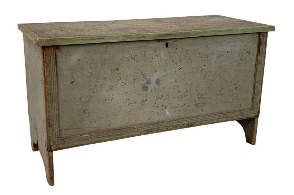 19th Century Painted Blanket Chest: A 19th century painted blanket chest in green, featuring distinctive bootjack ends and reeded trim detailing. The hinged lid opens to a spacious interior with a smaller rectangular cubby on the right