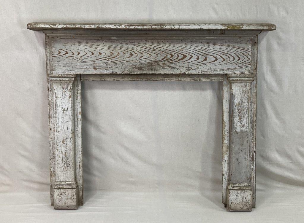 19th Century Southern Painted Fireplace Mantle: A 19th century Southern fireplace mantel crafted in yellow pine, featuring a simple rectangular shelf above a plain frieze set on a pair of molded pilasters terminating in plinth feet. The white