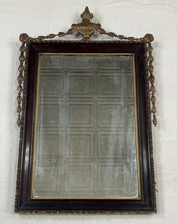 Neoclassical-Style Mirror: An antique neoclassical-style mirror featuring gilt detailing, surmounted by an urn with vegetal swag motif. Measures approximately 35â€³ H x 23â€³ W x