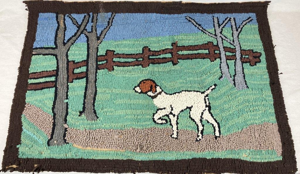 Antique Folk Art Hooked Hunting Dog Rug: An antique hand-hooked folk art rug on a burlap base, depicting a hunting dog in a pastoral landscape with trees and a fence in the background. Exhibits a worn, aged patina consistent with use. Measur
