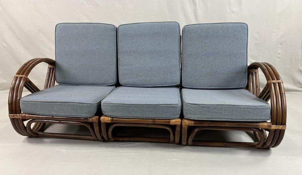 Mid Century Modern Rattan Pretzel Modular Sofa: A Mid Century Modern rattan modular sofa in the style of Paul Frankl, featuring distinctive pretzel-shaped arms and a sculptural woven frame. The design is complemented by blue upholstered cushions,