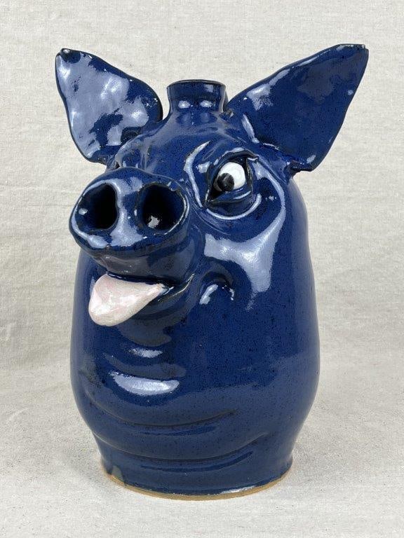 Marvin Bailey Pig Face Jug: A Southern stoneware cream riser finished in a rich, runny alkaline glaze, exhibiting characteristic surface variation from the firing process. Measures approximately 9″ H x 11 1/2″ in