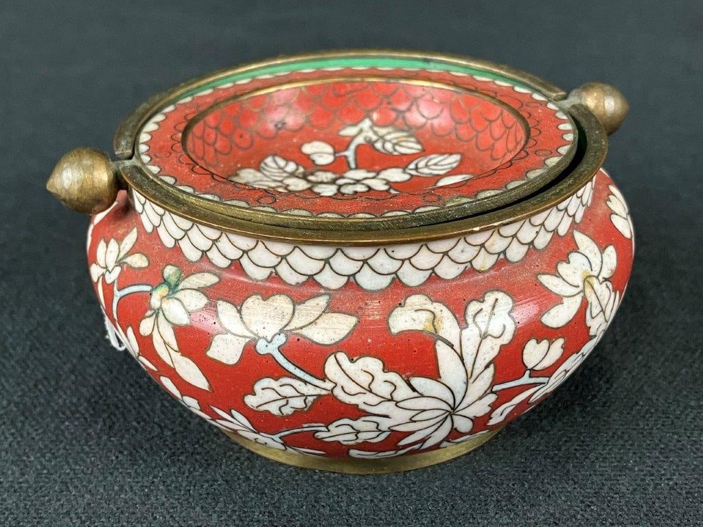 Chinese Cloisonné Covered Incense Burner: A petite Chinese cloisonné covered incense burner decorated with rich red and pale enamel tones. Measures approximately 2″ H x 3 1/4″ in diameter. In good condition. 