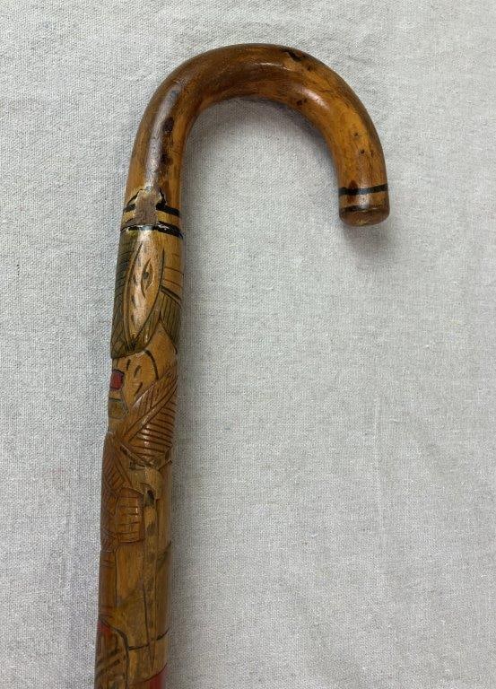 Mexican Folk Art Carved Wood Cane: A Mexican folk art carved wood cane featuring native figurative and plant life motifs with â€œMexicoâ€ incised into the design. The surface is carved in low relief