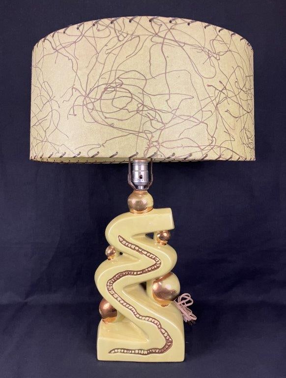 Mid Century Modern Howard Kron â€œZig Zagâ€ Lamp: A Mid Century Modern Howard Kron â€œZig Zagâ€ lamp featuring a ceramic form glazed in a vibrant chartreuse green-yellow tone with gold tone accented details. The