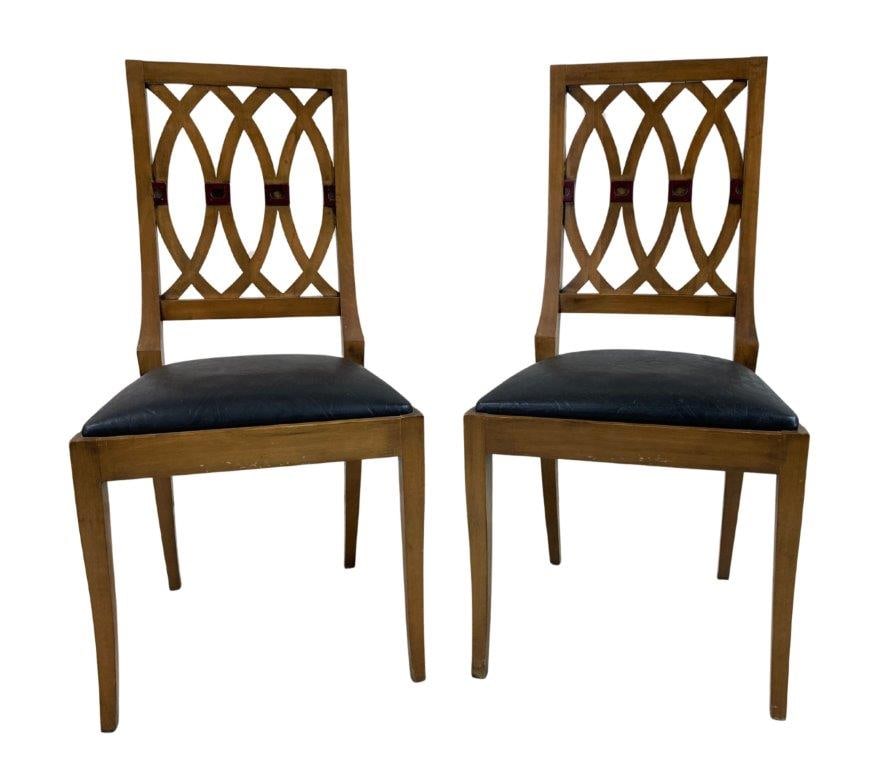 Neoclassical Style Fruitwood Chairs: A pair of neoclassical style chairs featuring embossed leather seats with decorative detailing, set within softly toned wood frames exhibiting a warm natural patina. The curving reticulated backs are
