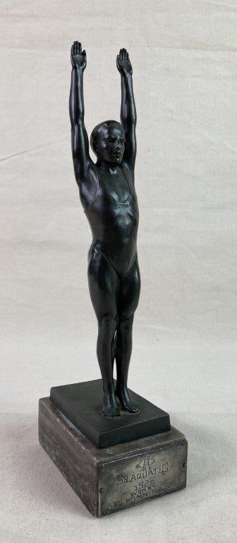 Antique German Diver Trophy: An Art Deco–style trophy featuring a male diver posed with both arms raised. The base bears an engraved plaque reading “Sr. Aquatic 1928 Won by C. Finnigan.” Displays a worn, aged