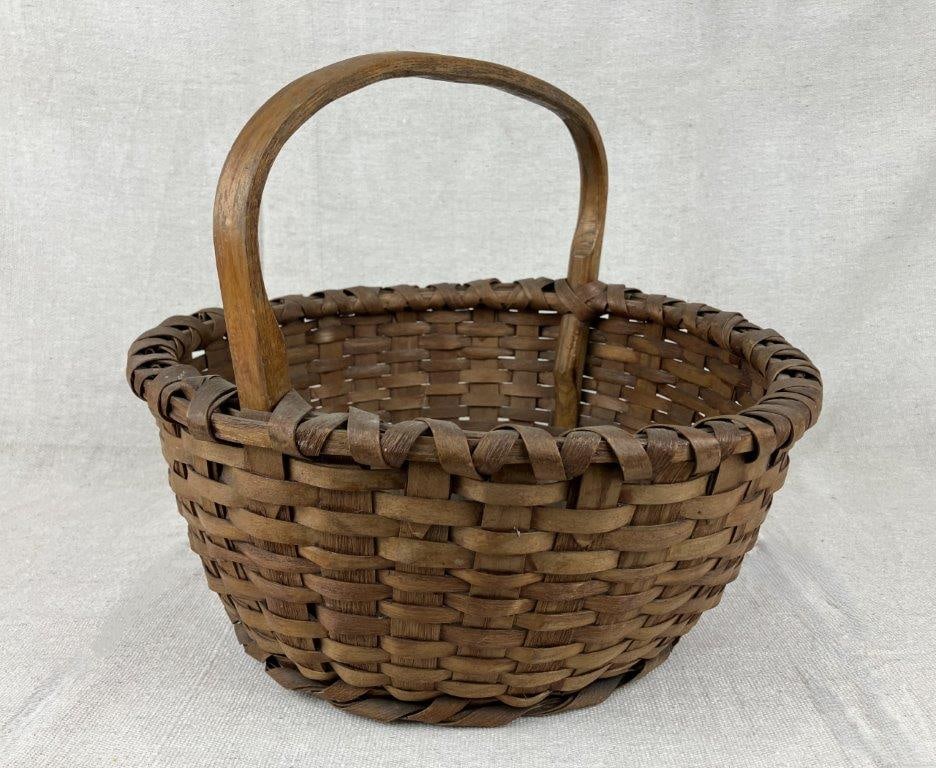 Country Split Oak Gathering Basket: A country split oak gathering basket with a wrapped rim and rich, mellowed patina. Measures approximately 11″ H x 13″ in diameter. Shows little wear and remains in overall good condition